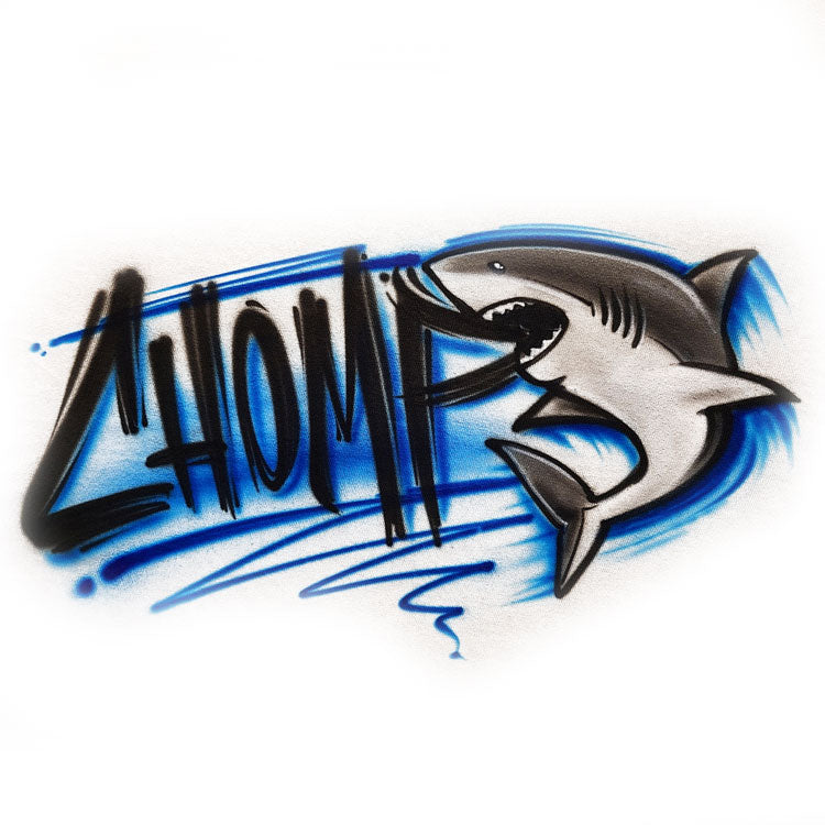 White tank top with airbrushed graffiti-style lettering that says “CHOMP” and a detailed shark illustration biting through the design, with blue streaks and shading.