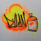 Custom airbrush shirt featuring a neon spray paint graffiti design with the name "Dylan" and a colorful spray can illustration in orange, green, and yellow.
