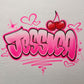 Custom airbrush shirt with bold pink bubble graffiti lettering, surrounded by hearts, sparkles, and topped with a red cherry design.

